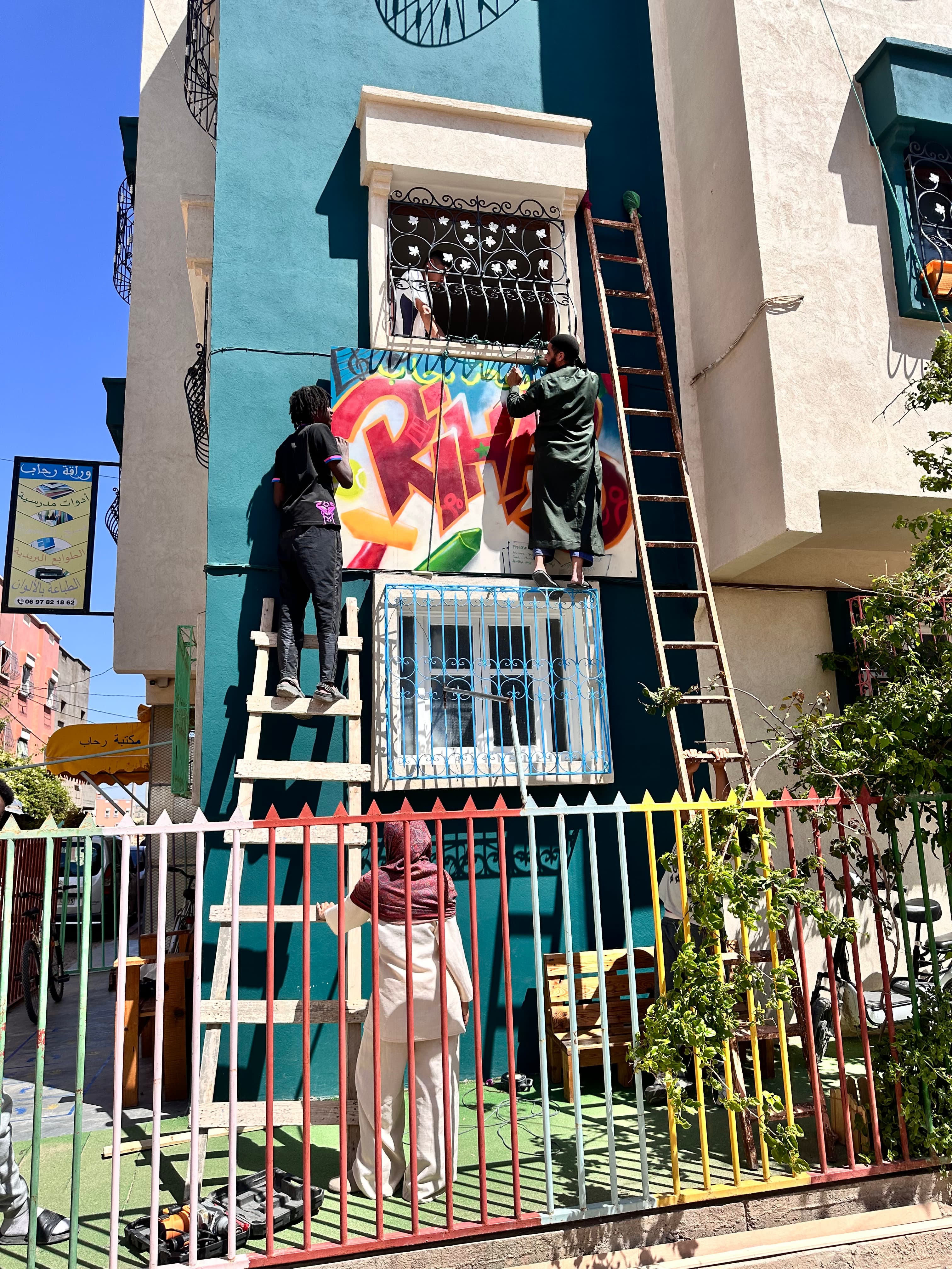 Installation d'une pancarte sur la façade d'une école au Maroc